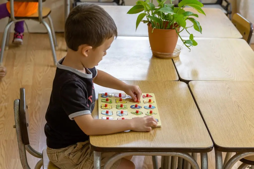 a child working on arithmetic using Montessori golden bead materials