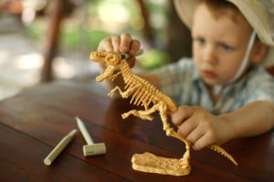 a child tracing geometric shapes using Montessori metal insets