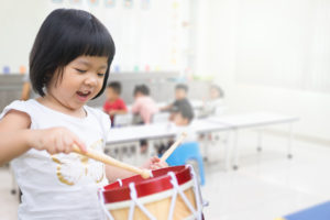 a child exploring geometric solids to learn about three-dimensional shapes